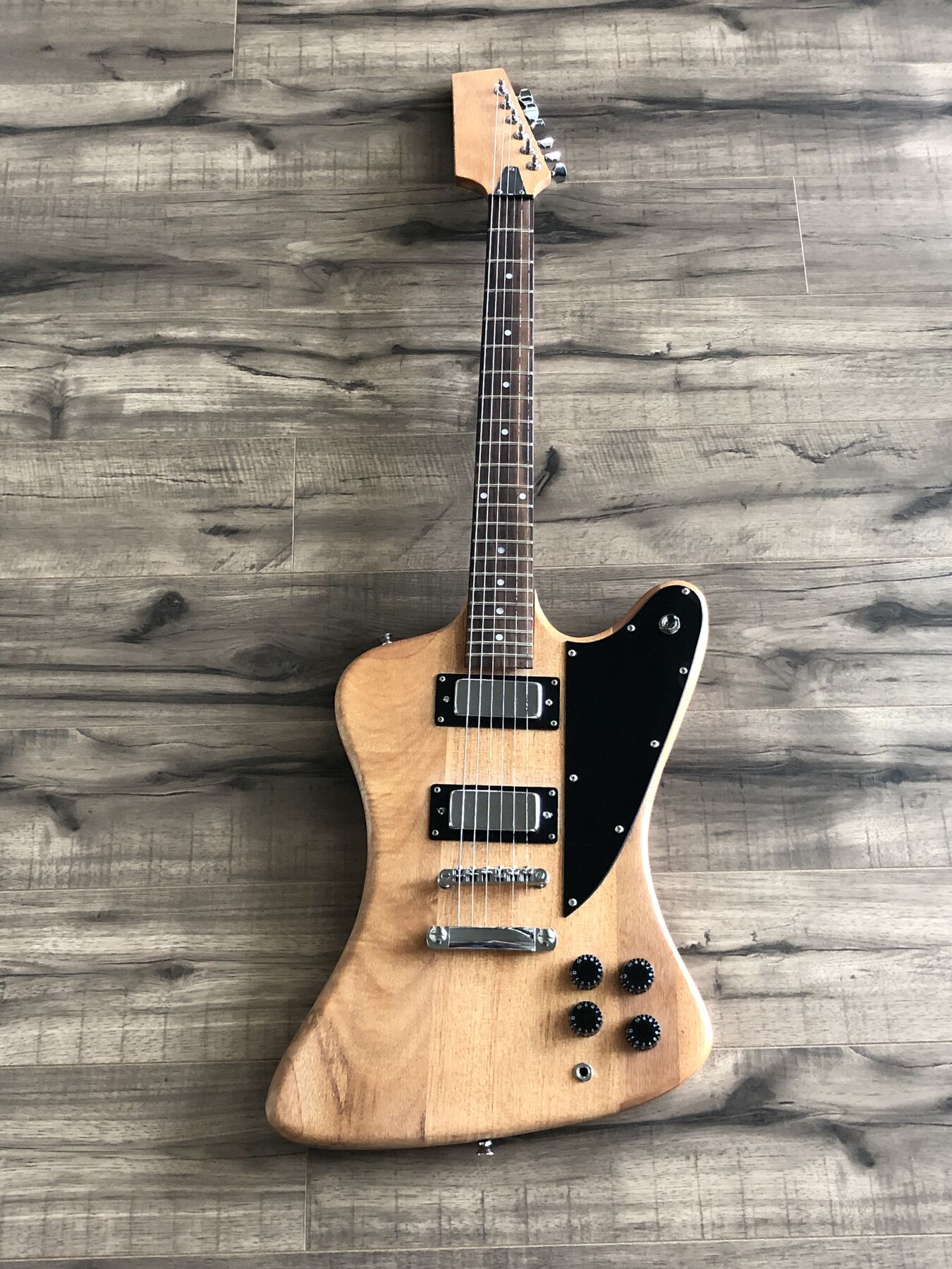 Natural-finish reverse-body guitar with a black pickguard and two mini humbuckers