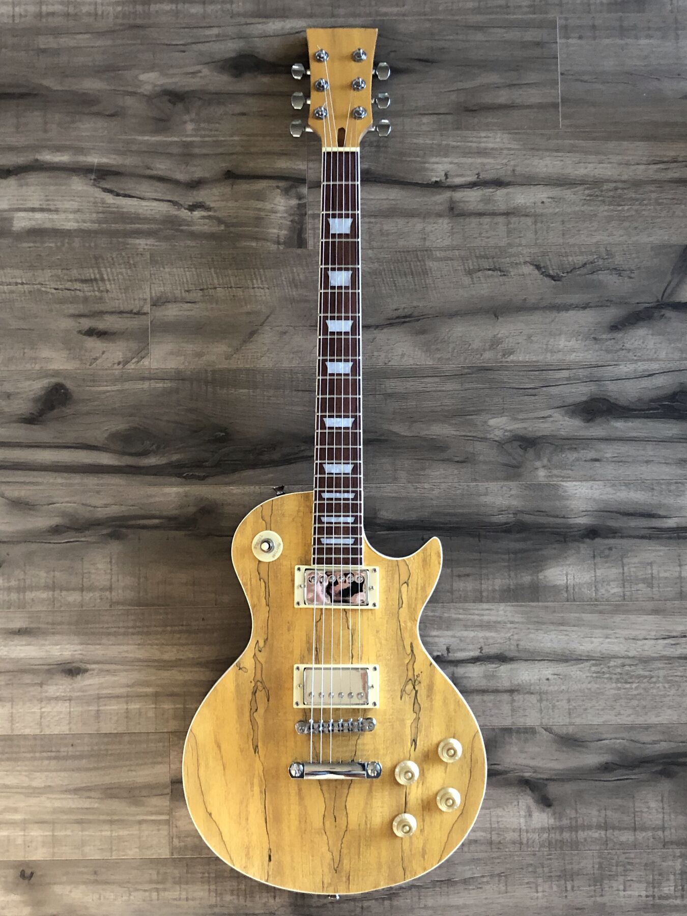 Single-cutaway guitar with a yellow spalted maple top, cream binding and two humbuckers