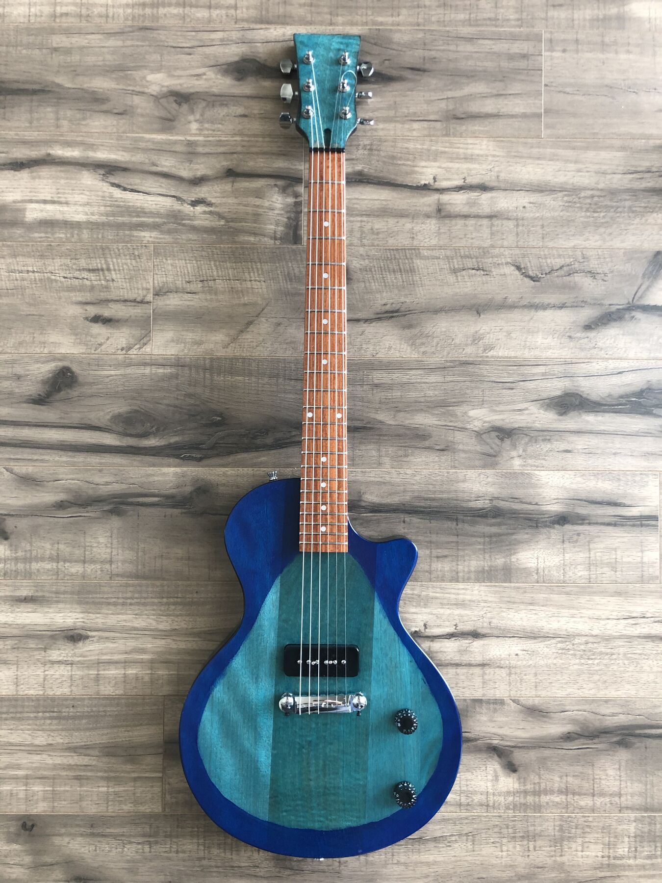 Single-cutaway guitar in a teal-to-blue burst with one black P90 pickup